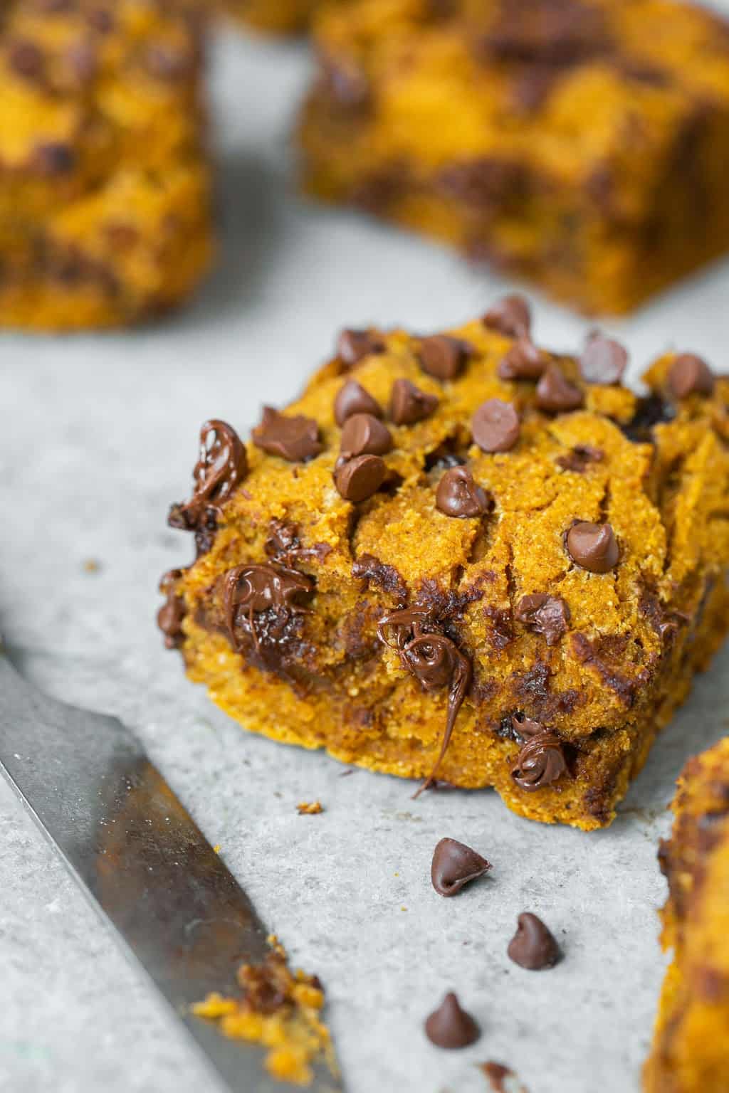 Zoomed in view of healthy pumpkin chocolate chip blondies with melty chocolate chips.