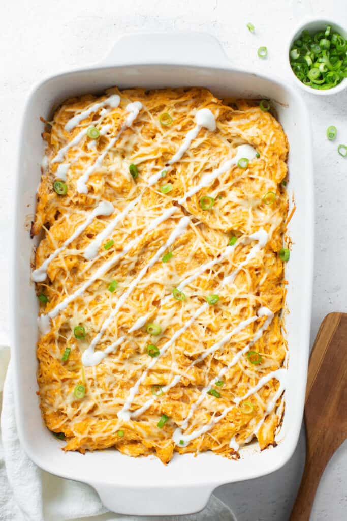 Buffalo chicken, spaghetti squash, and cheese baked in a casserole dish topped with green onions and dressing.