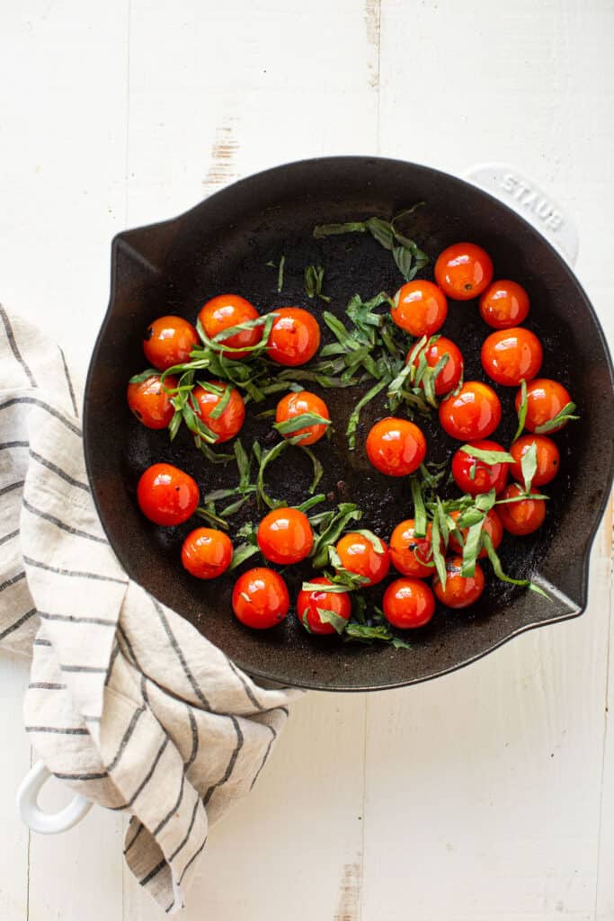 Small tomatoes on the vine in a black skillet