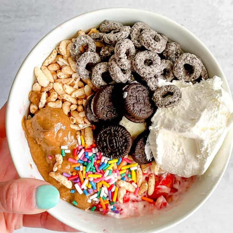 Jello Yogurt Bowl topped with rice puffs, peanut butter, sprinkles, cereal, and mini oreos