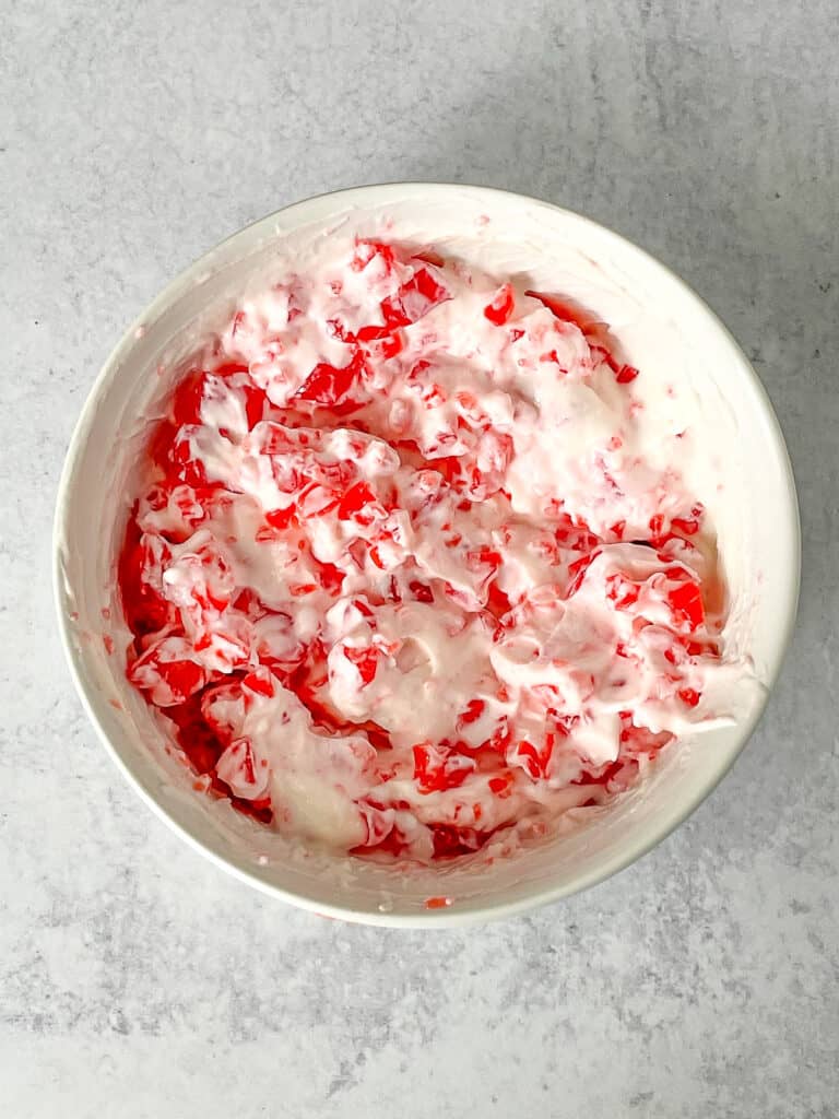 Yogurt mixed with strawberry gelatin in a bowl