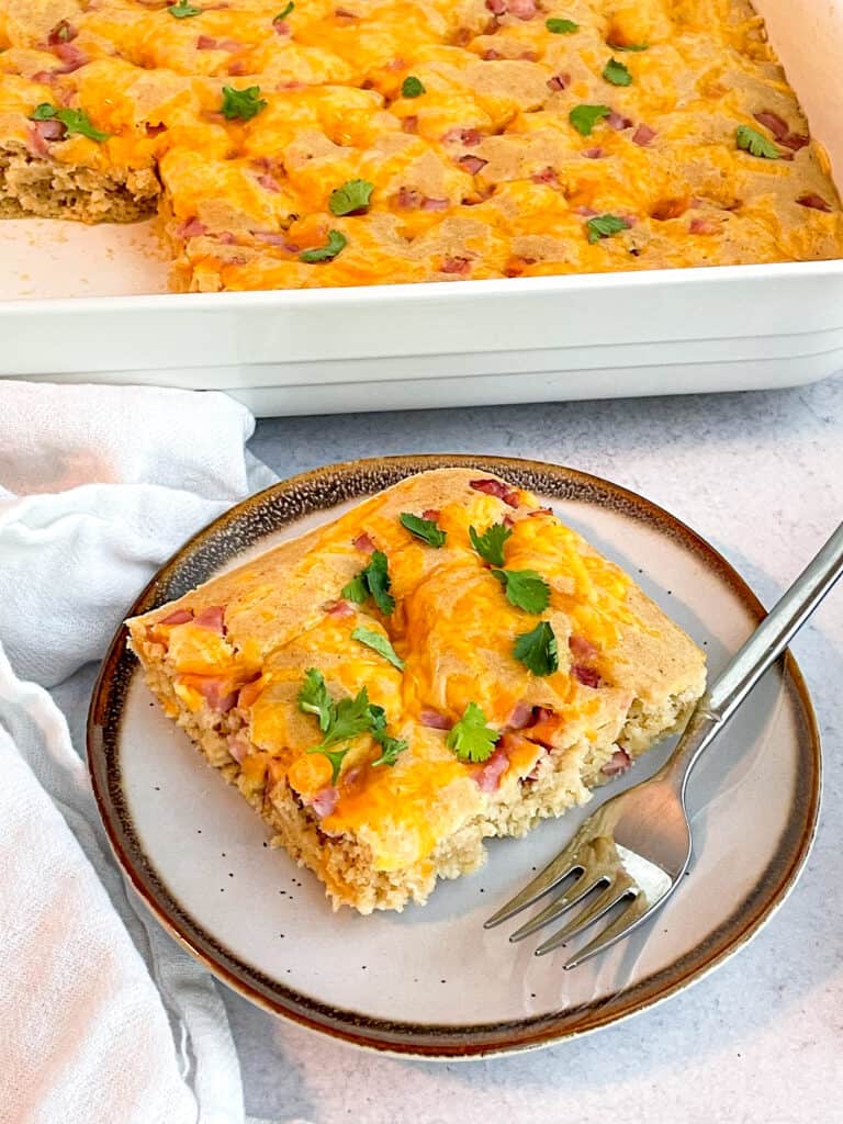 one serving of ham and cheese breakfast bake on a plate with a fork. 
