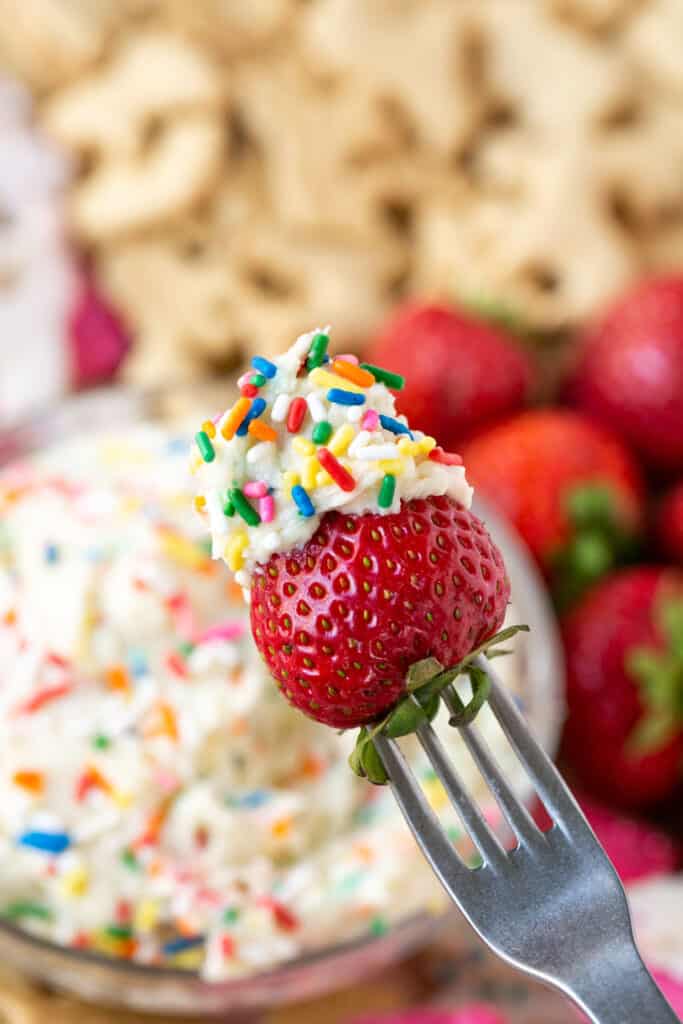 A fork with a strawberry topped with Dunkaroo Dip.