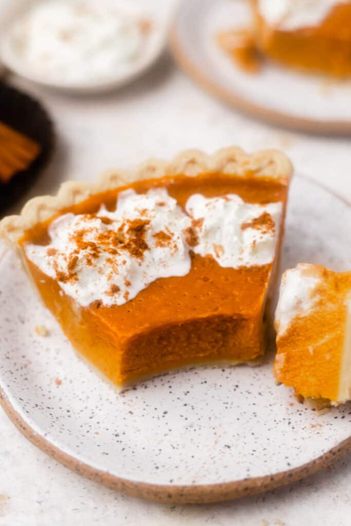 healthy pumpkin pie on a plate with whipped cream 