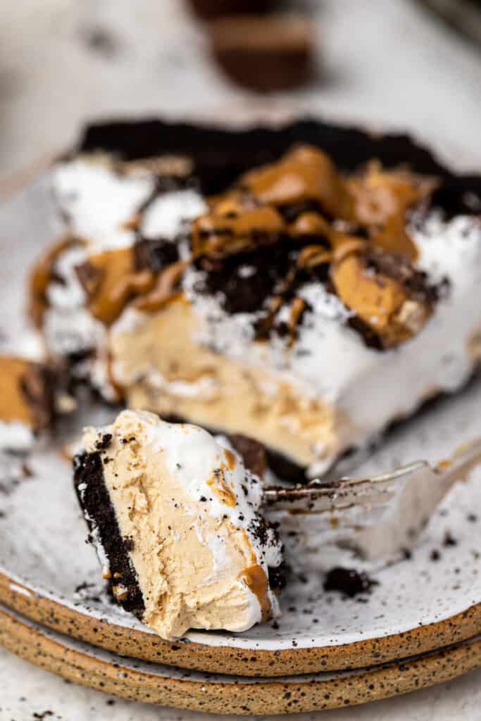 Zoomed in view of no bake oreo peanut butter pie topped with chopped Reese's on a small plate.
