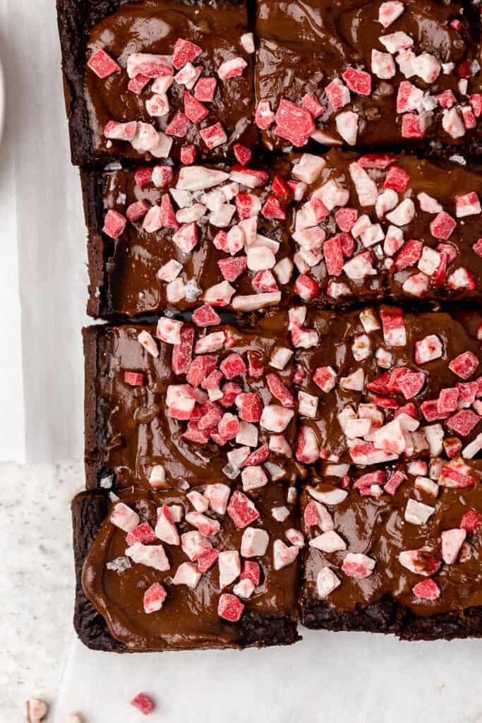 Zoomed in view of peppermint brownies cut into bars on parchment paper.