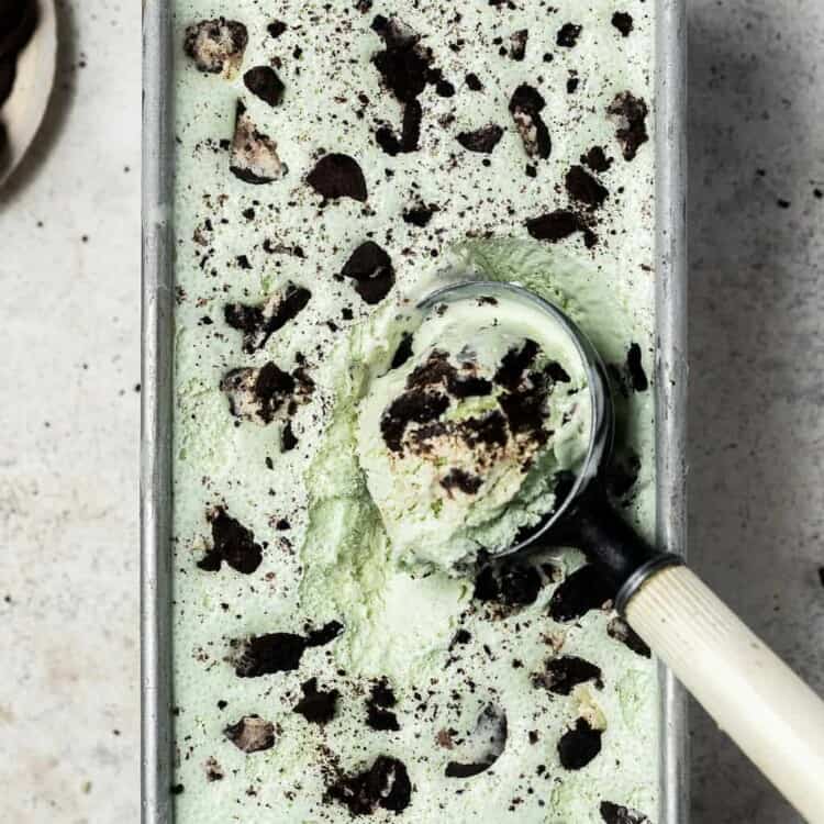 Mint protein ice cream in a rectangle pan with an ice cream scoop.