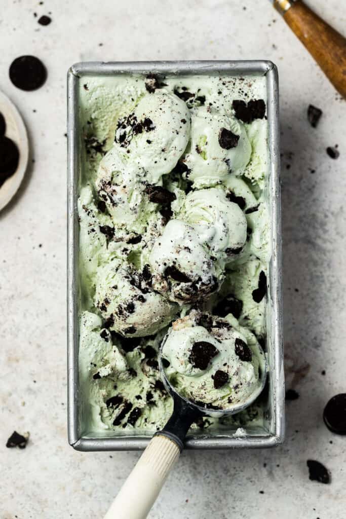 Mint protein ice cream in a rectangle pan with an ice cream scoop.