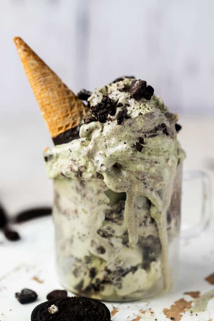 Mint protein ice cream in a jar topped with oreos and an ice cream cone.