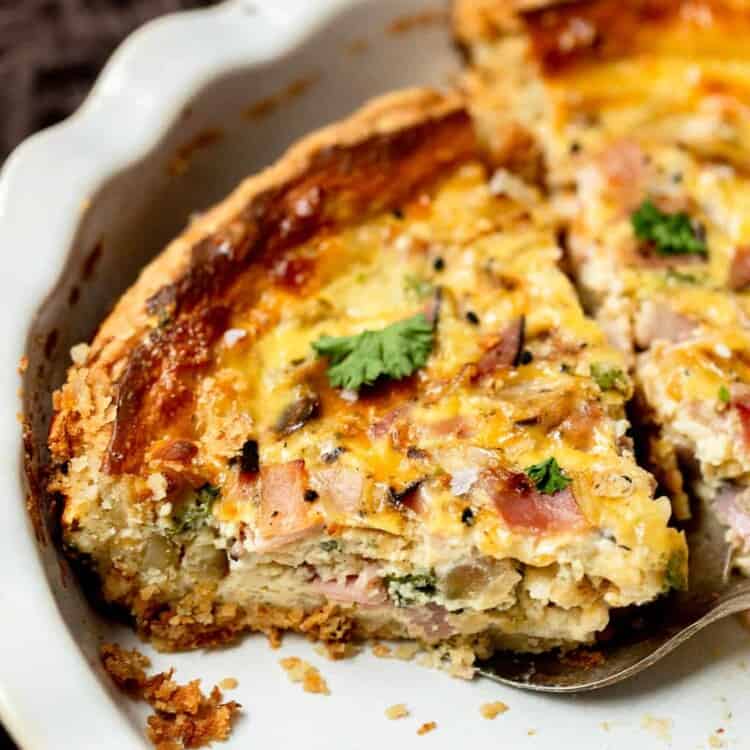 Ham and cheese quiche sliced in a pie pan.