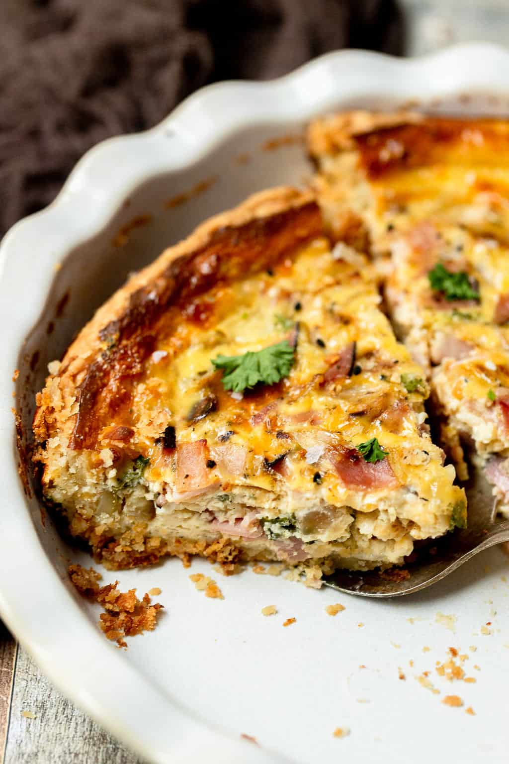 Ham and cheese quiche sliced in a pie pan.