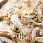 Zoomed in view of shredded chicken in a bowl.