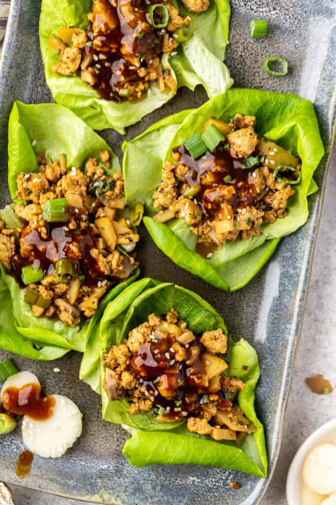 Macro friendly Chicken Lettuce Wraps on a serving plate topped with green onion