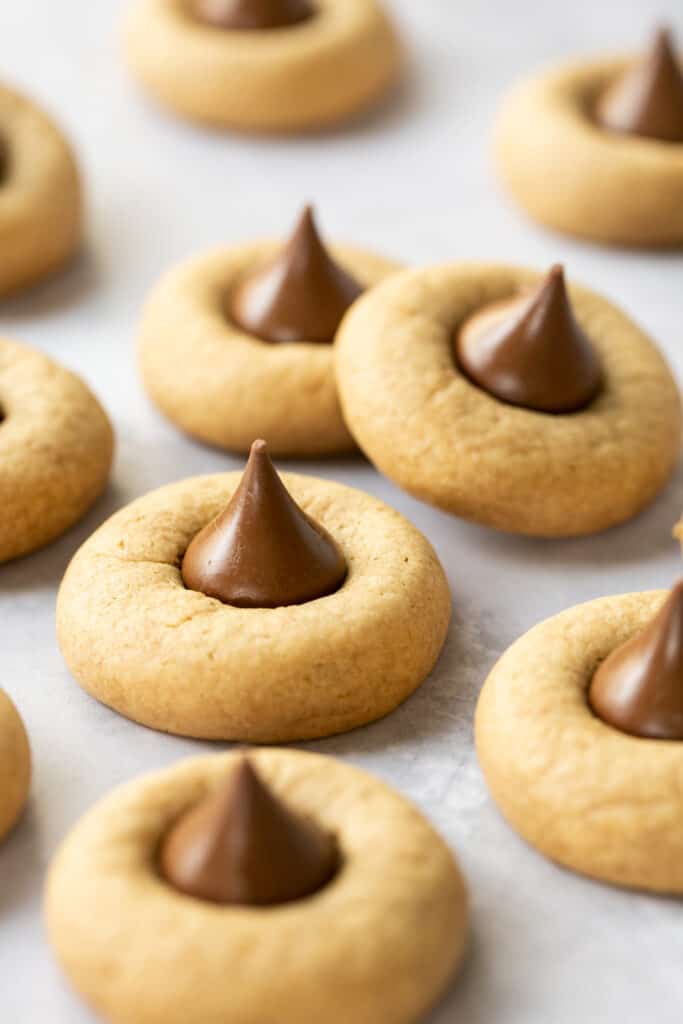 Peanut butter blossom cookies on parchment paper.