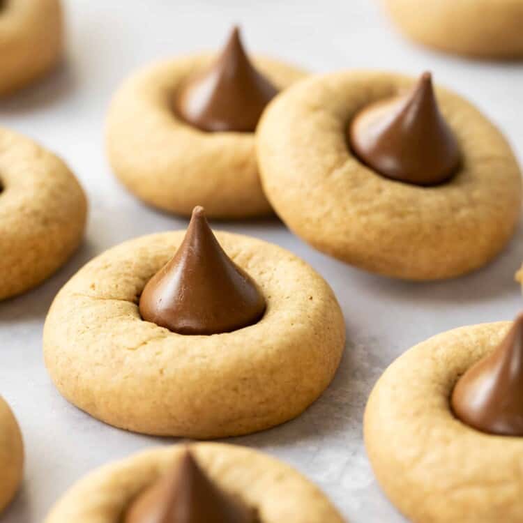 Peanut butter blossom cookies on parchment paper.