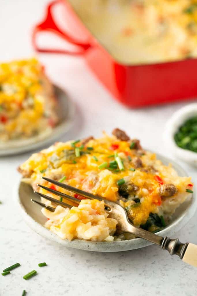 Cheesy hashbrown casserole on a plate with a fork.