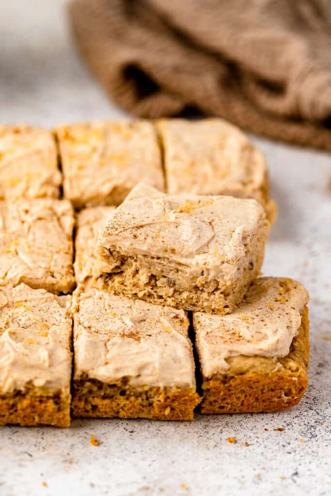 Banana Blondies with Cinnamon Brown Butter Frosting cut into squares on parchment paper