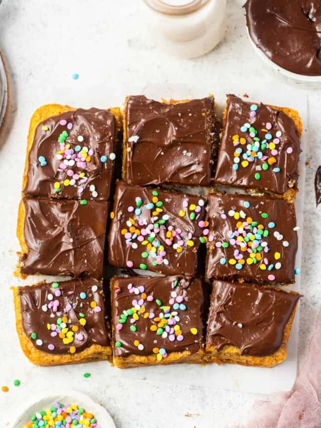 Healthy yellow cake with chocolate frosting topped with sprinkles and cut into squares