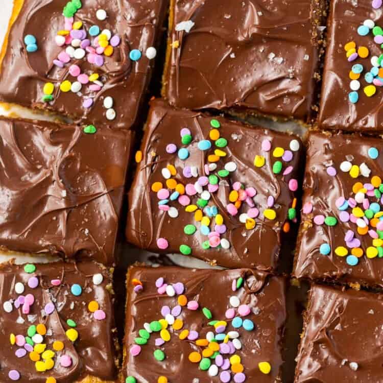 Healthy yellow cake topped with chocolate frosting and sprinkles cut into nine squares.