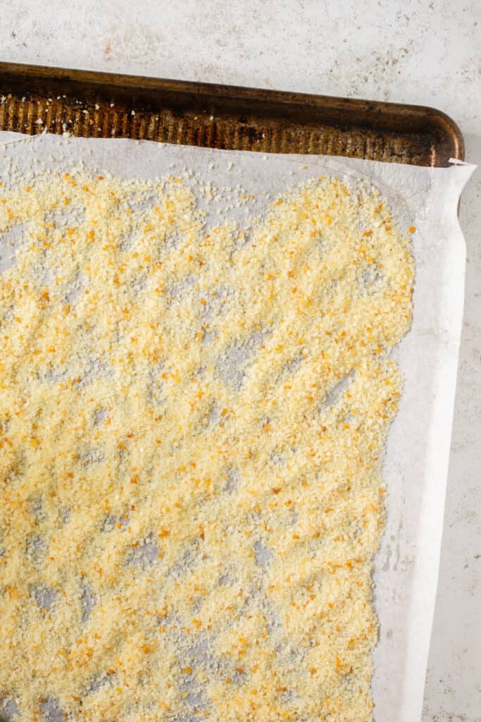 Bread crumbs on a baking sheet with parchment paper.