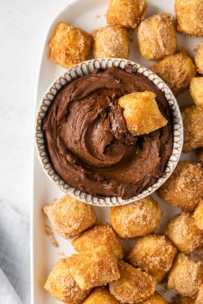 Cinnamon pretzel bites with a pretzel dipped into a small bowl of homemade nutella on the side.
