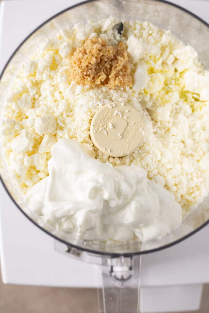 Ingredients for whipped feta in a food processor before being mixed together.