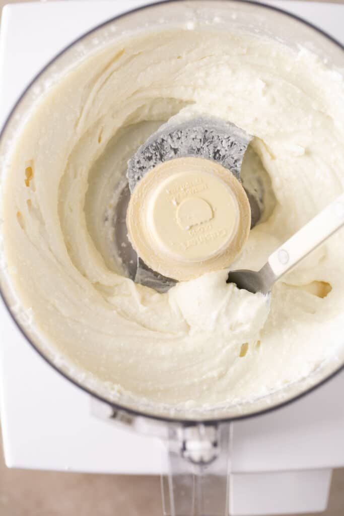 Ingredients for whipped feta in a food processor after being mixed together.