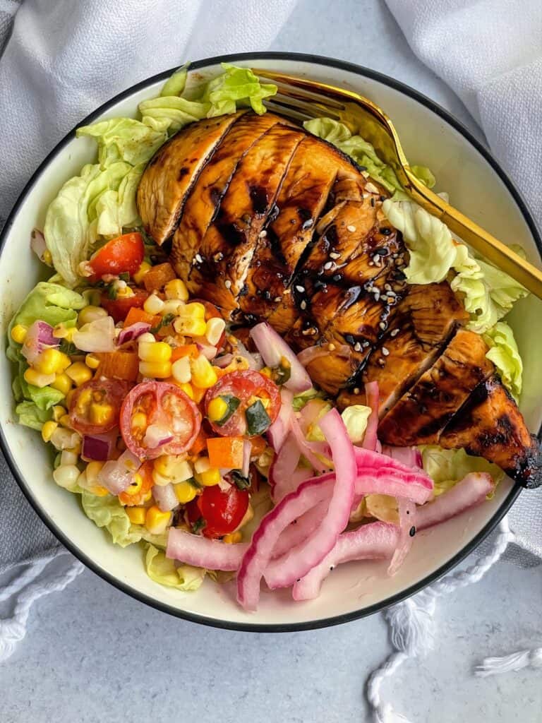 Smoky Grilled Chicken on greens with  corn salsa and red onion