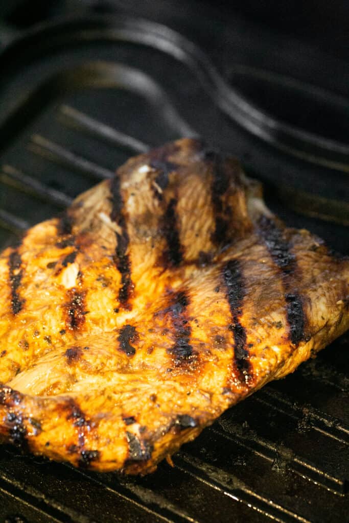 Grilled chicken on a grill plate.