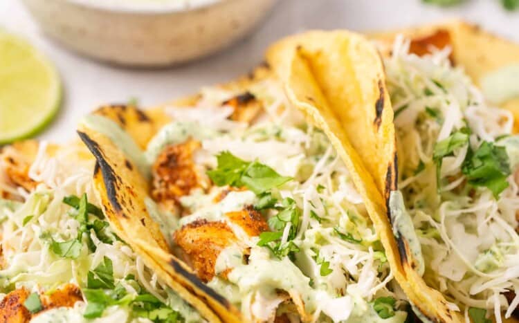Blackened mahi tacos with a side of cilantro lime crema in a bowl.