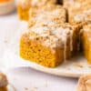 Healthy Pumpkin Coffee Cake squares topped with glaze on a plate.