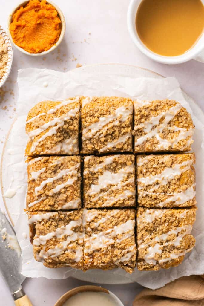 healthy pumpkin poffee cake with brown sugar crumb topping on a plate cut into nine squares