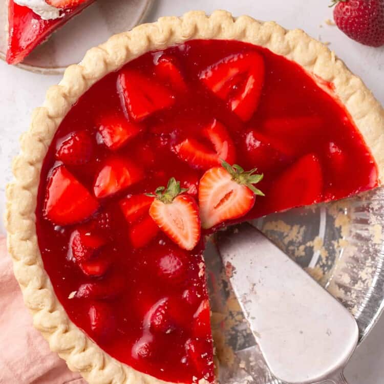 Strawberry pie with jello being sliced.