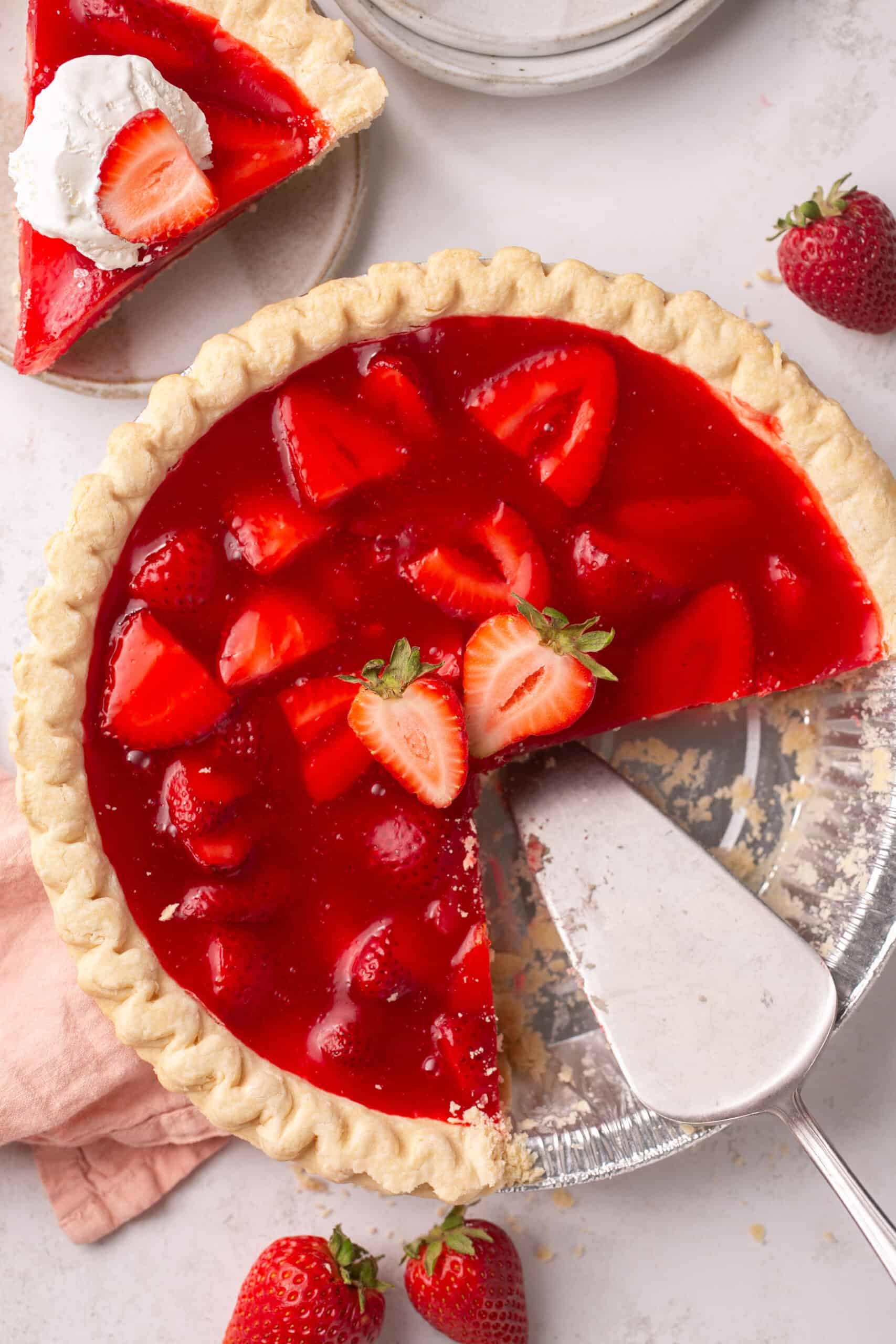 Strawberry pie with jello being sliced.