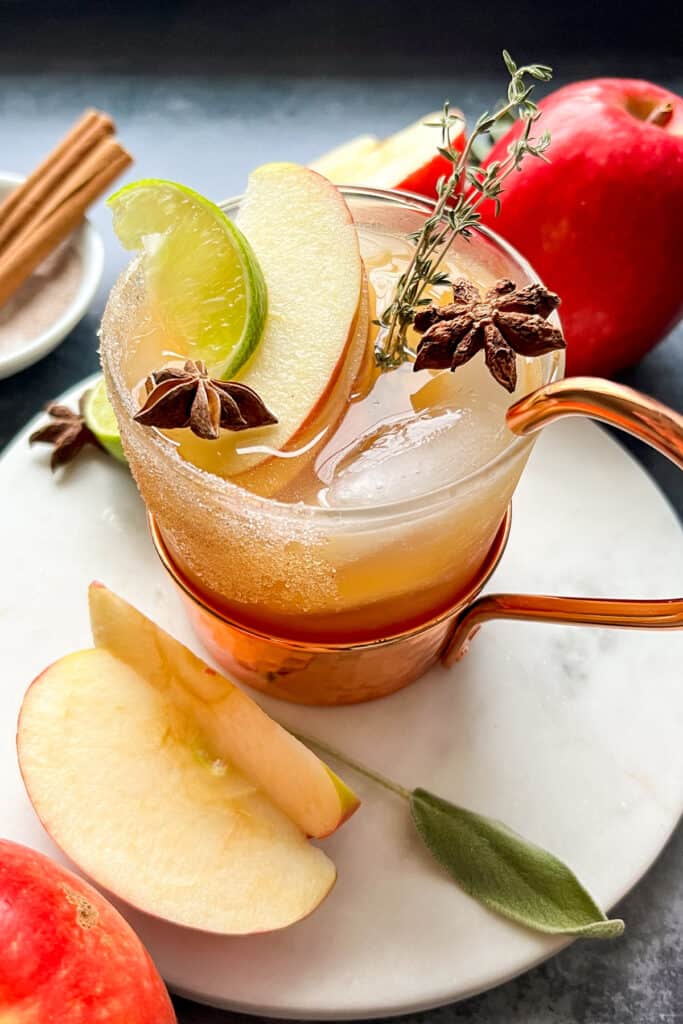 Apple Cider Margarita in a short glass garnished with lime, apple slices, and star of anise.