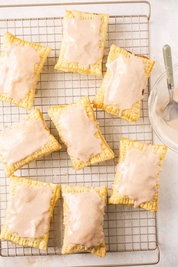 Brown sugar cinnamon pop tarts topped with frosting on a cooling rack