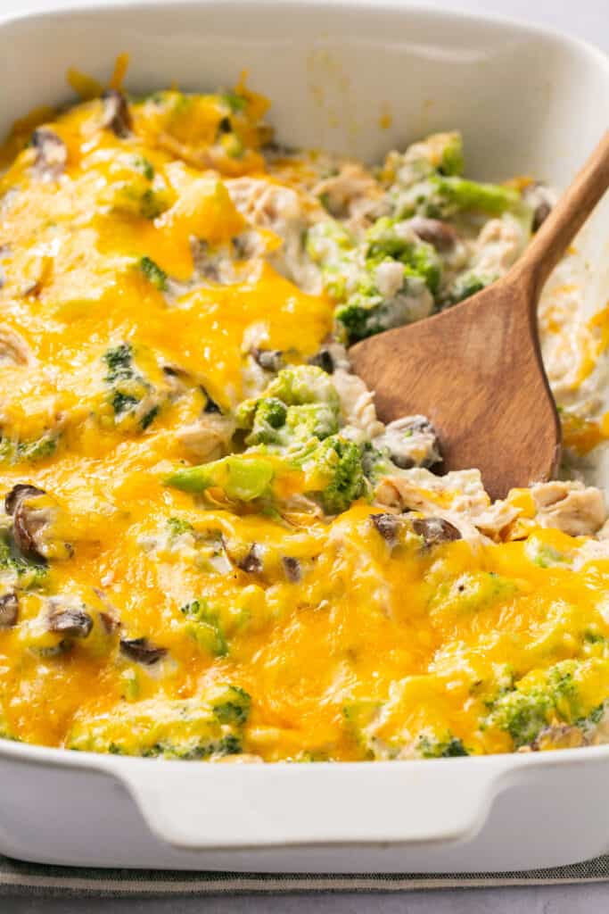 Macro Friendly Chicken Broccoli Casserole in a baking dish with a wooden spoon