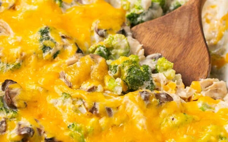 Chicken and Broccoli Casserole in a Casserole dish being scooped out with a spoon.