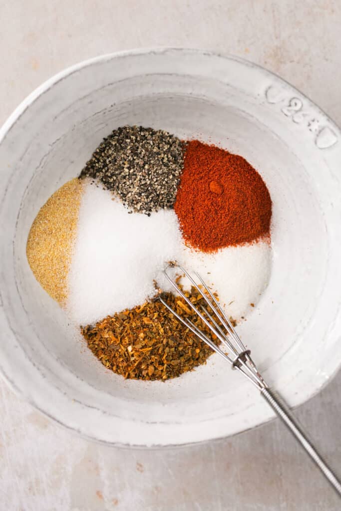 Ingredients for dry rub in a small bowl with a whisk.