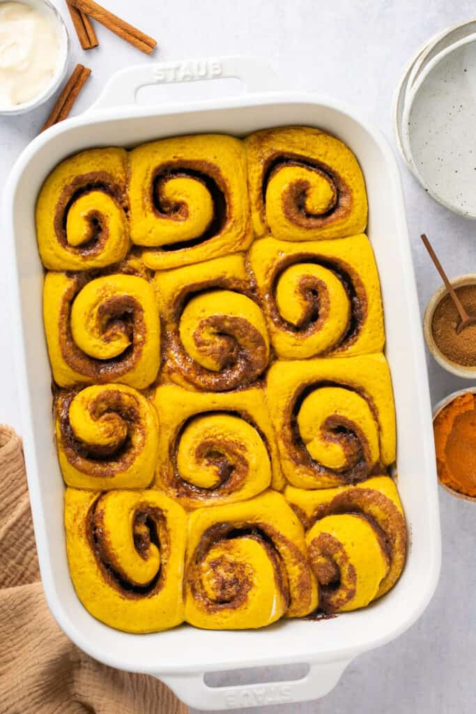 Healthy pumpkin cinnamon rolls in a baking dish with no icing after being baked