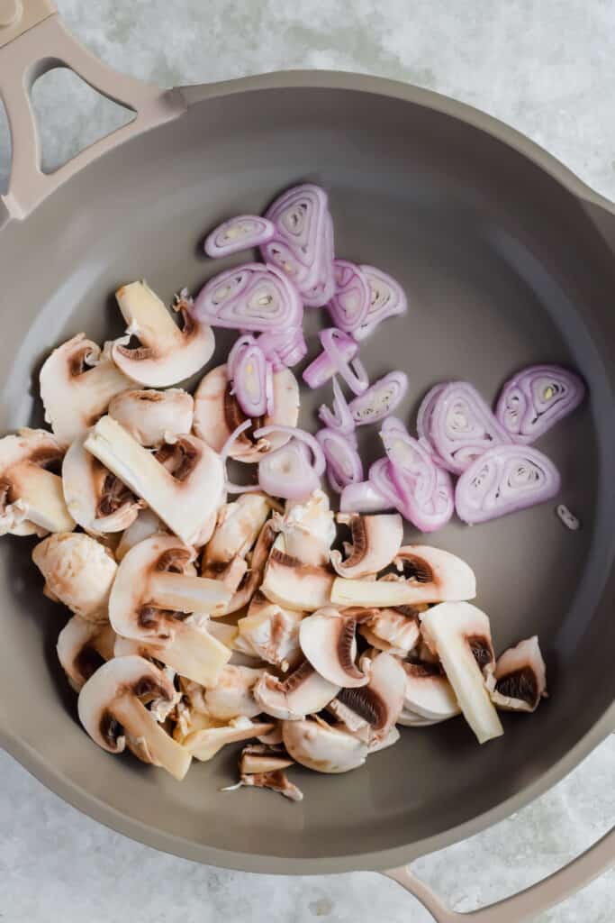Mushrooms and shallots in a skillet.