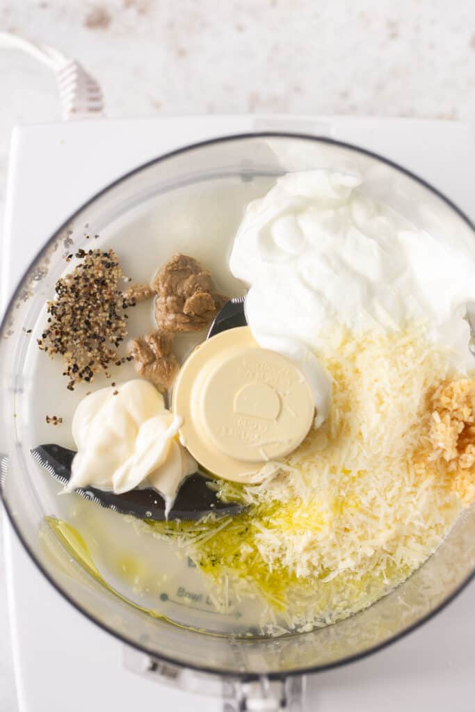 adding all homemade low calorie caesar dressing ingredients in a food processor 