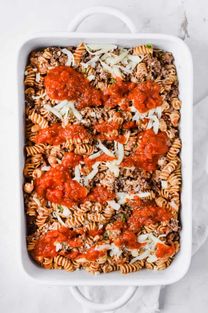 Rotini pasta bake in a baking dish before being baked.