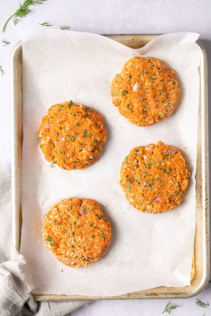 Salmon patties on a baking sheet with parchment paper.