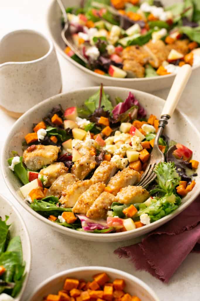 Fall Harvest Salad with Pecan Chicken and Sweet Potatoes in a bowl with a fork
