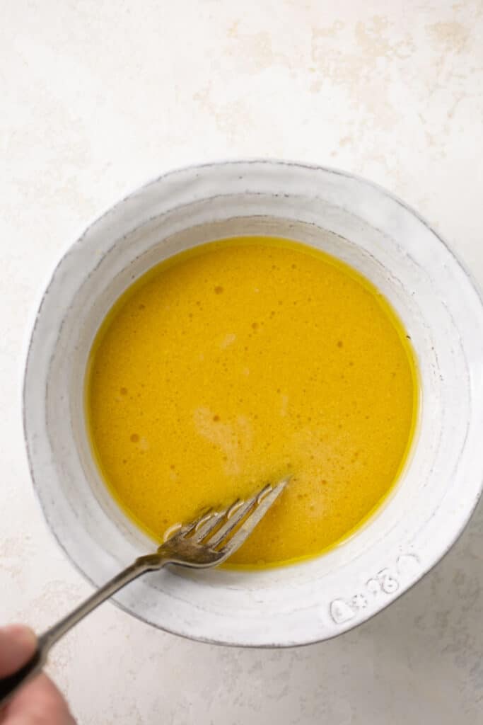 Honey mustard dressing in a bowl with a spoon.