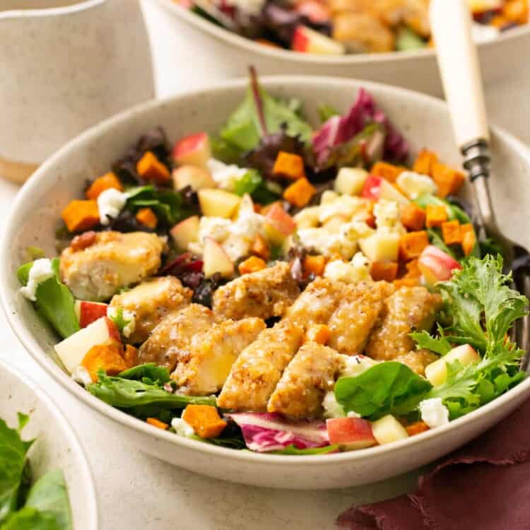 Fall Harvest Salad with Pecan Chicken and Sweet Potatoes in a bowl with a fork.