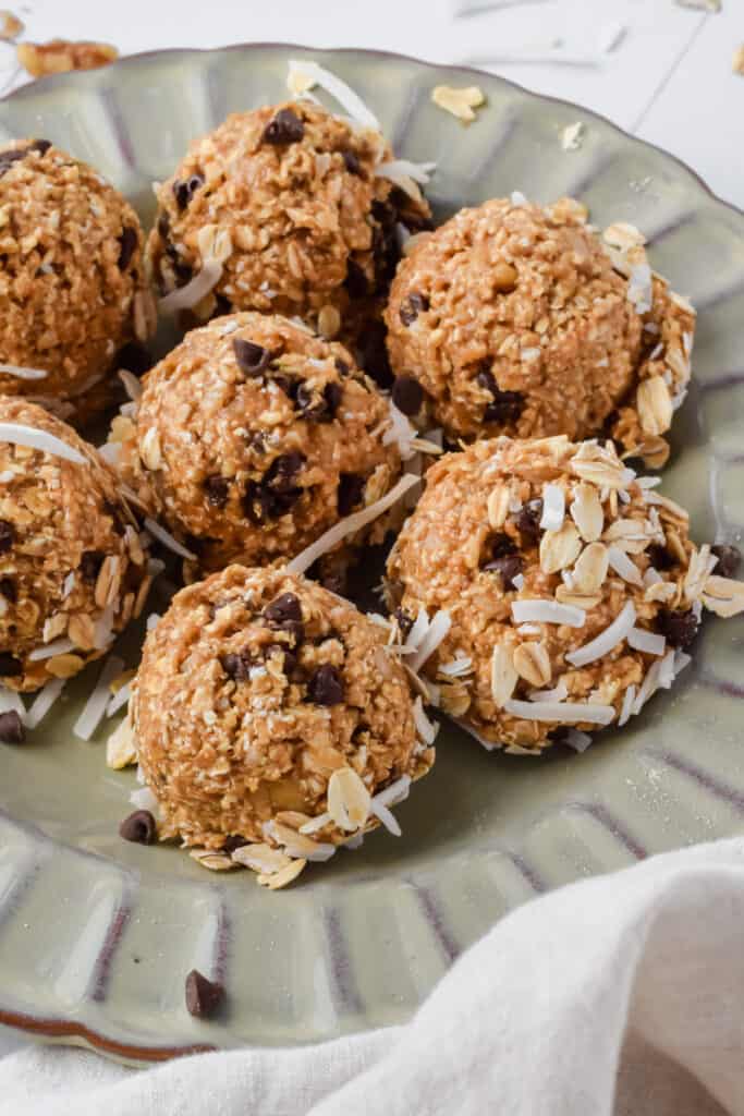 Zoomed in view of oatmeal cashew cookie coconut protein balls on a plate.