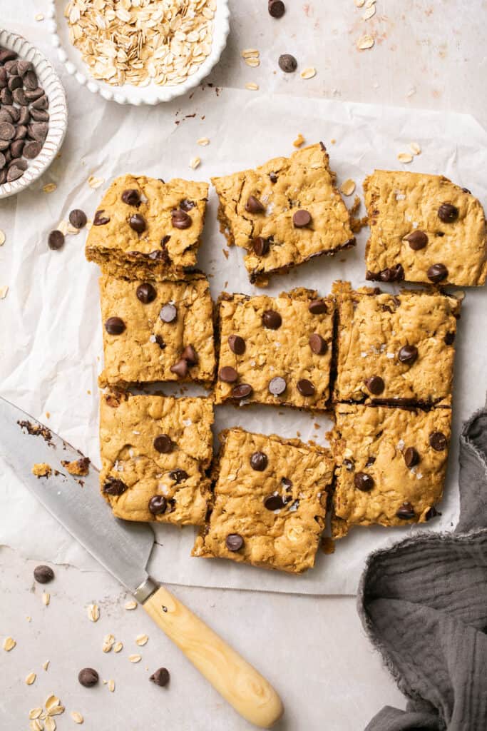 Healthy peanut butter oatmeal cookie bars cut into squares on parchment paper.