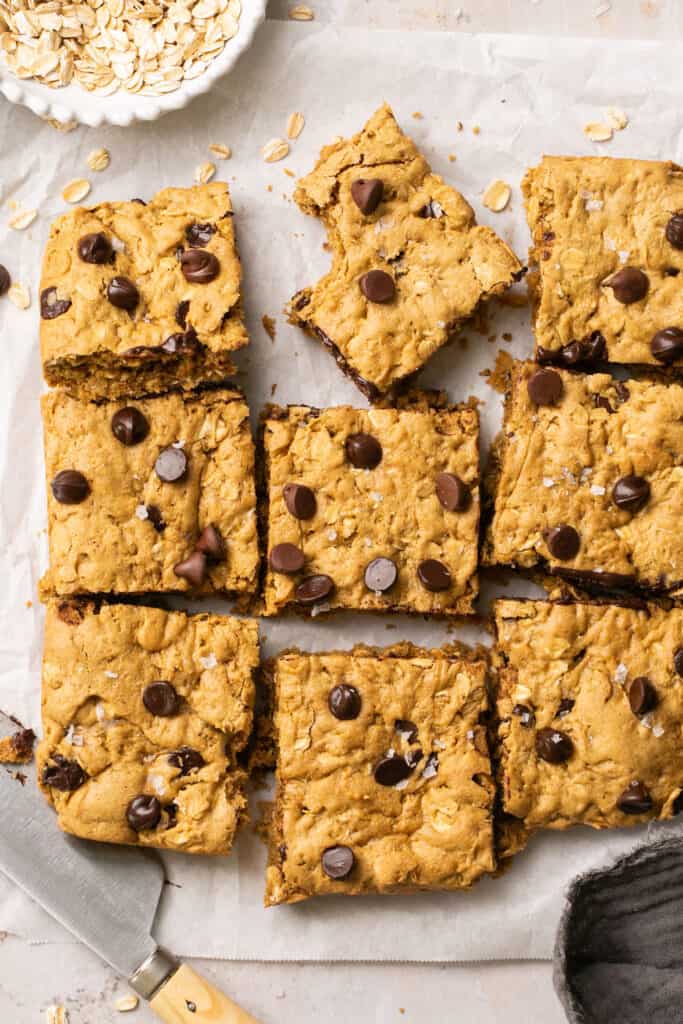 Healthy peanut butter oatmeal cookie bars cut into squres on parchment paper.